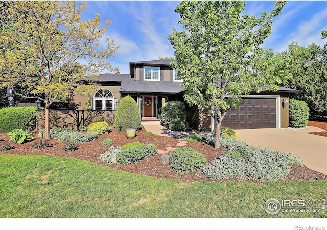 view of front of home featuring concrete driveway, a front lawn, and an attached garage
