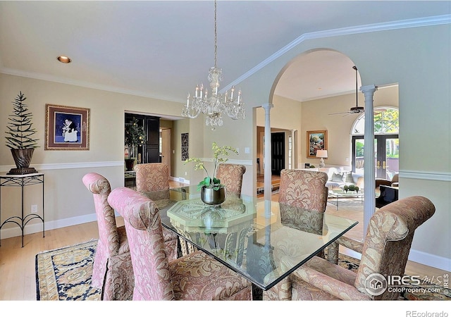 dining room with arched walkways, wood finished floors, decorative columns, ceiling fan, and baseboards