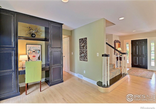 foyer entrance with light wood-style flooring, stairway, baseboards, and recessed lighting