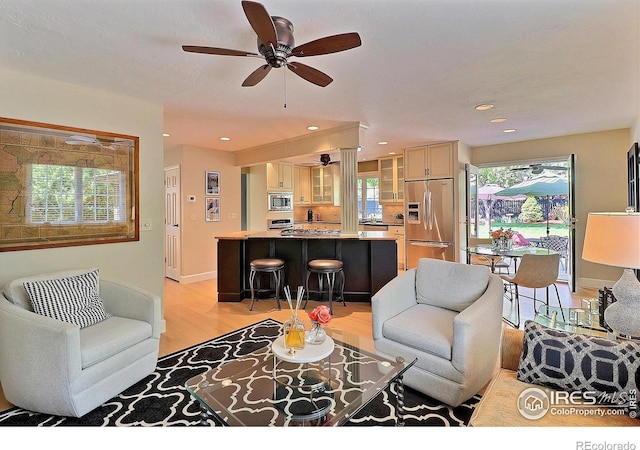 living room with a ceiling fan, light wood-style floors, and recessed lighting