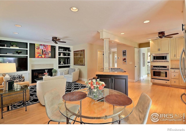 dining area with ceiling fan, light wood-style floors, baseboards, a glass covered fireplace, and recessed lighting