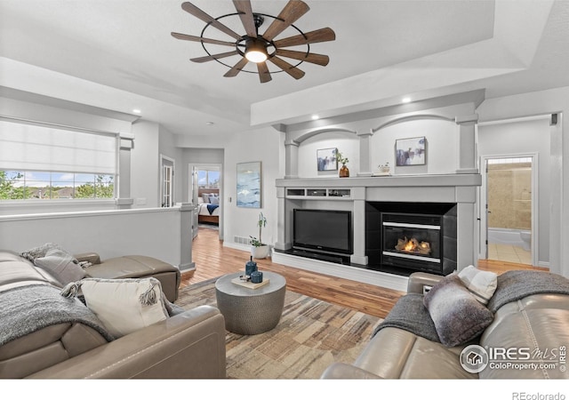 living room featuring a ceiling fan, baseboards, wood finished floors, healthy amount of natural light, and recessed lighting