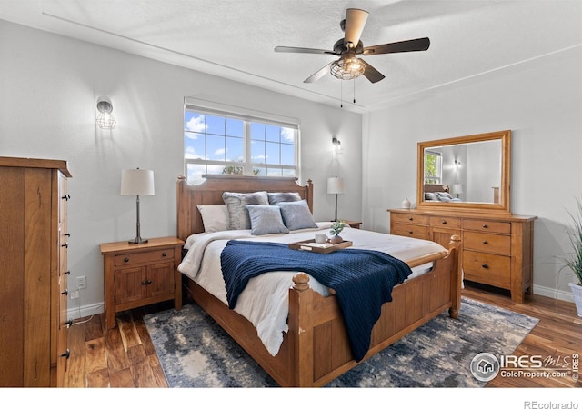 bedroom with baseboards, wood finished floors, and ceiling fan
