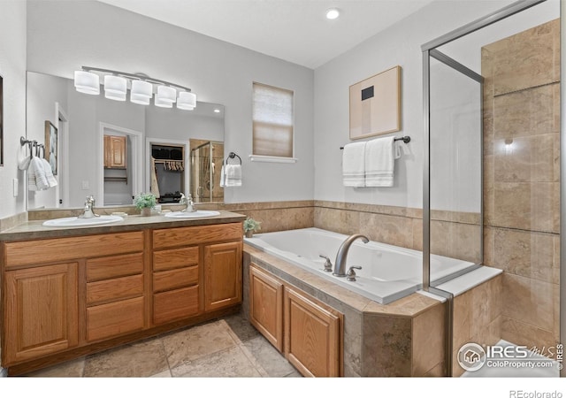 full bathroom with a stall shower, a garden tub, double vanity, and recessed lighting