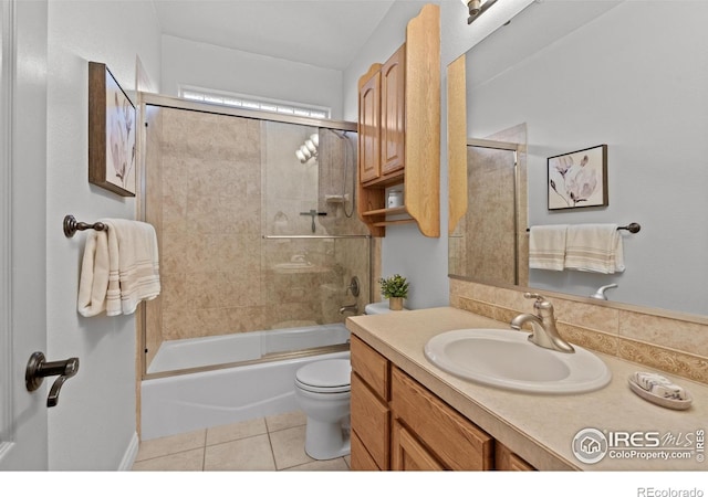 bathroom with toilet, tile patterned floors, vanity, and shower / bath combination with glass door