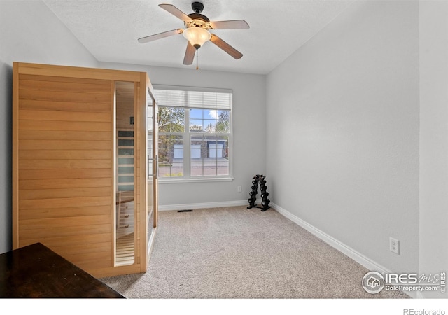 unfurnished bedroom featuring carpet, baseboards, a relaxing sauna, and a ceiling fan