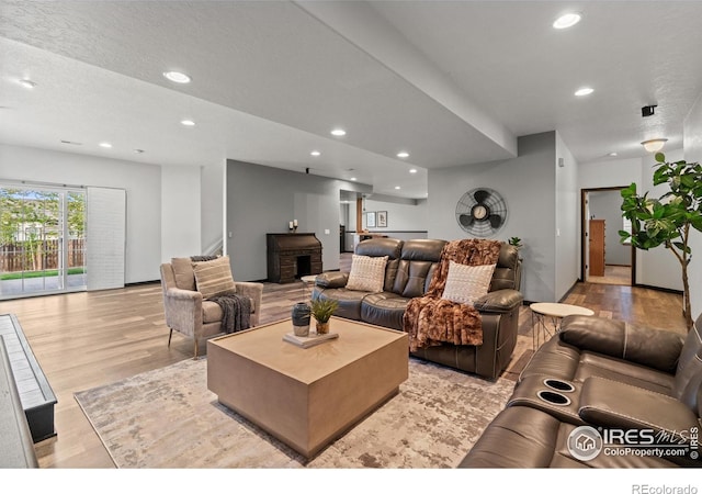 living area with light wood-type flooring and recessed lighting