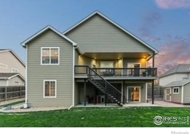 back of house with stairway, a patio area, a wooden deck, an outdoor structure, and a storage unit