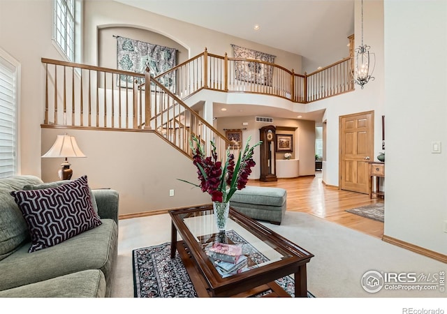 14180 Whitney Cir, Broomfield, CO 80023 - carpeted living area featuring a chandelier, stairs, baseboards, a high ceiling, and wood finished floors