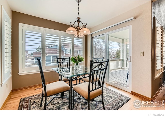 14180 Whitney Cir, Broomfield, CO 80023 - dining area featuring light wood-style floors, baseboards, and a chandelier
