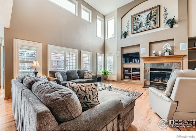 14180 Whitney Cir, Broomfield, CO 80023 - living room with a high ceiling, a premium fireplace, wood finished floors, and plenty of natural light