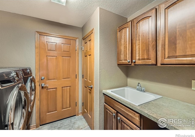14180 Whitney Cir, Broomfield, CO 80023 - clothes washing area featuring cabinet space, washer and dryer, a textured wall, a textured ceiling, and light tile patterned floors