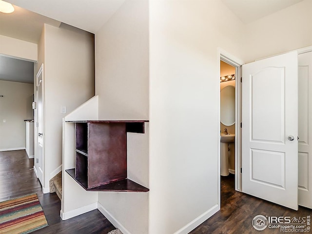 hallway featuring dark wood finished floors and baseboards