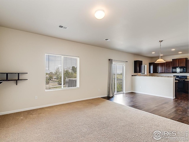 unfurnished living room featuring dark colored carpet, baseboards, and recessed lighting