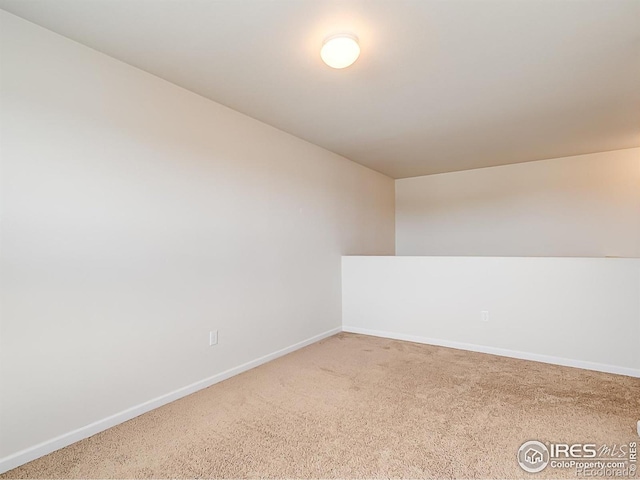 carpeted spare room with baseboards