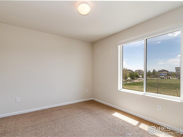 carpeted empty room with baseboards and plenty of natural light