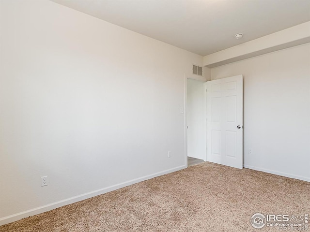 carpeted empty room featuring baseboards and a smoke detector
