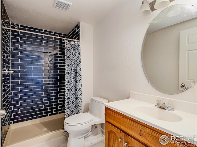 bathroom featuring toilet, vanity, and a shower stall