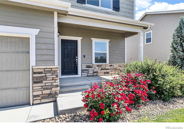 920 Wagon Bend Rd, Berthoud, CO 80513 - view of exterior entry featuring stone siding, a garage, and a porch