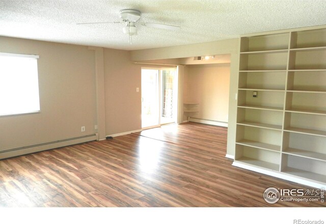 4150 Monroe Dr Unit C, Boulder, CO 80303 - spare room featuring baseboard heating, a textured ceiling, ceiling fan, wood finished floors, and baseboards