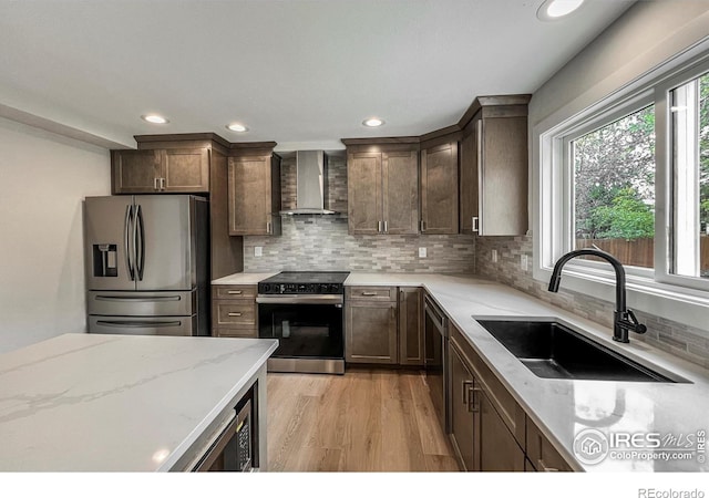 5978 Scotswood Ct, Boulder, CO 80301 - kitchen with stainless steel appliances, wall chimney exhaust hood, a sink, light stone counters, and tasteful backsplash
