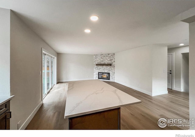 5978 Scotswood Ct, Boulder, CO 80301 - unfurnished living room featuring light wood-type flooring, baseboards, recessed lighting, and a stone fireplace