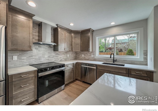 5978 Scotswood Ct, Boulder, CO 80301 - kitchen featuring stainless steel dishwasher, wall chimney range hood, range with electric cooktop, a sink, and light wood-type flooring