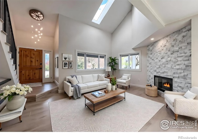 5978 Scotswood Ct, Boulder, CO 80301 - living room with high vaulted ceiling, stairway, a skylight, baseboards, and a fireplace