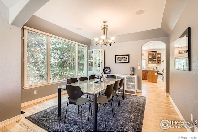 933 Xenon Ct, Golden, CO 80401 - dining room with arched walkways, light wood-style floors, a chandelier, and baseboards