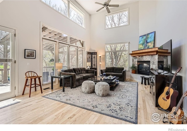 933 Xenon Ct, Golden, CO 80401 - living area featuring wood finished floors, a premium fireplace, ceiling fan, and a towering ceiling