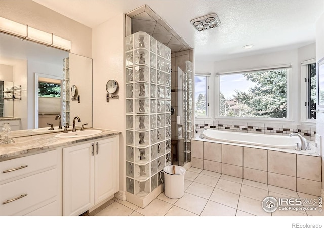 933 Xenon Ct, Golden, CO 80401 - bathroom featuring tile patterned flooring, vanity, a bath, a tile shower, and a textured ceiling