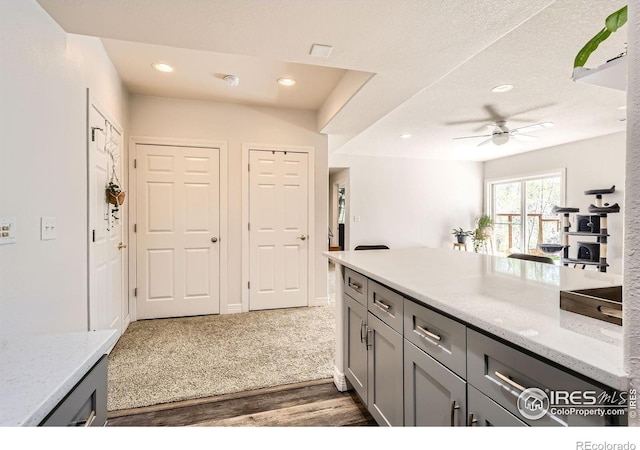 933 Xenon Ct, Golden, CO 80401 - kitchen with gray cabinets, a ceiling fan, dark wood finished floors, light stone countertops, and recessed lighting