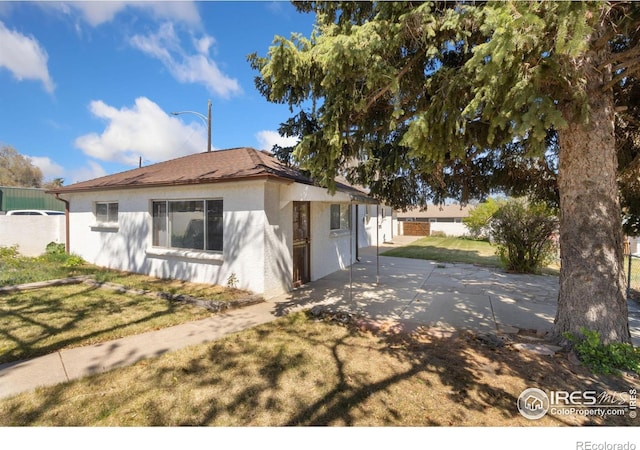 1334 N Jefferson Ave, Loveland, CO 80537 - view of front of home with stucco siding and a patio