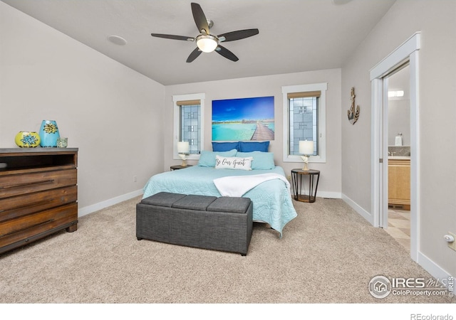 carpeted bedroom featuring baseboards, ensuite bath, and ceiling fan