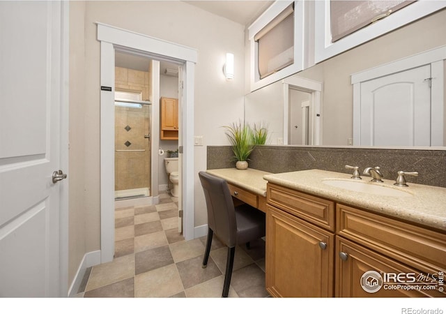 full bathroom featuring toilet, a shower stall, vanity, baseboards, and tile patterned floors