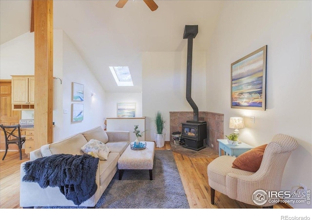 101 Spruce St, Jamestown, CO 80455 - living area featuring a wood stove, vaulted ceiling, wood finished floors, a skylight, and a ceiling fan