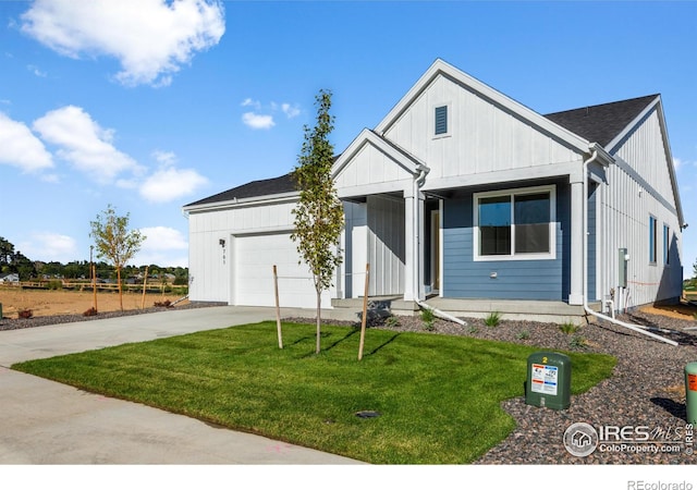 view of front of house with an attached garage, driveway, a front yard, and board and batten siding