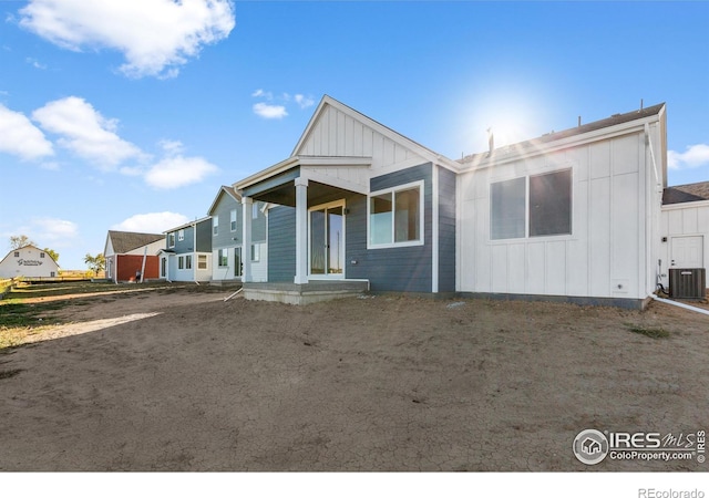 rear view of house featuring board and batten siding and cooling unit