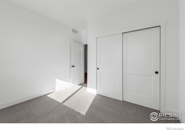unfurnished bedroom featuring carpet floors, a closet, and baseboards