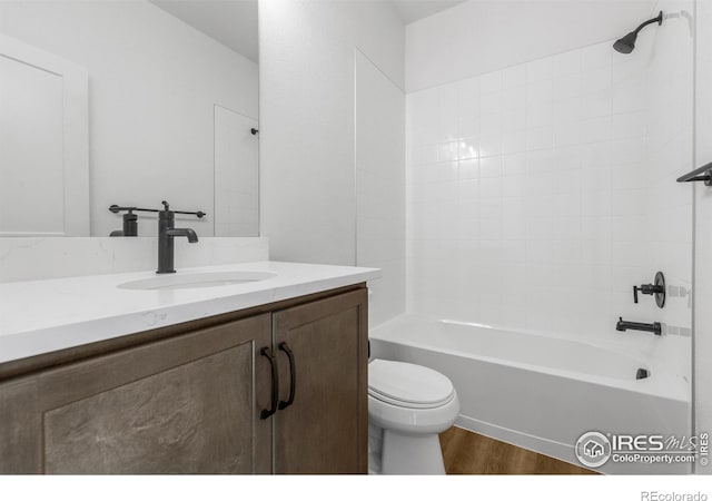 bathroom with toilet, wood finished floors, vanity, and bathtub / shower combination