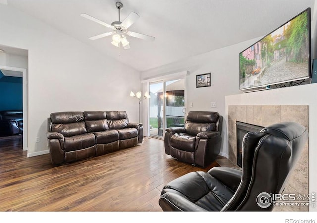 7037 Raleigh St, Wellington, CO 80549 - living room featuring vaulted ceiling, wood finished floors, ceiling fan, and a tiled fireplace