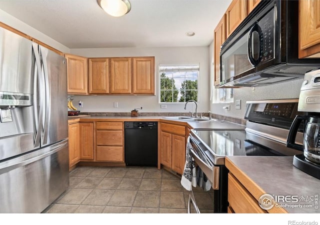 7037 Raleigh St, Wellington, CO 80549 - kitchen with black appliances, a sink, and light tile patterned flooring