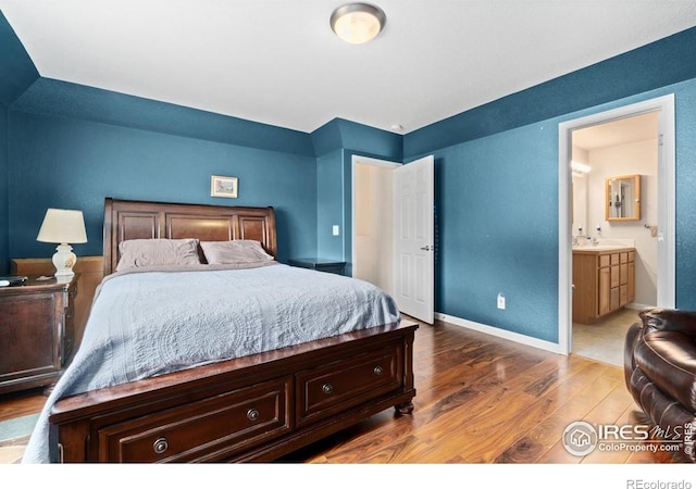 7037 Raleigh St, Wellington, CO 80549 - bedroom featuring wood finished floors, a sink, ensuite bath, and baseboards