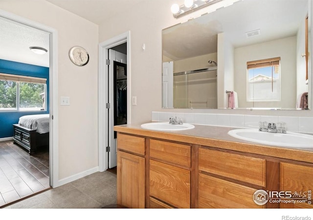 7037 Raleigh St, Wellington, CO 80549 - bathroom featuring a shower with shower door, double vanity, baseboards, tile patterned flooring, and connected bathroom