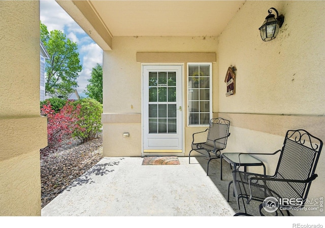entrance to property with stucco siding and a patio area