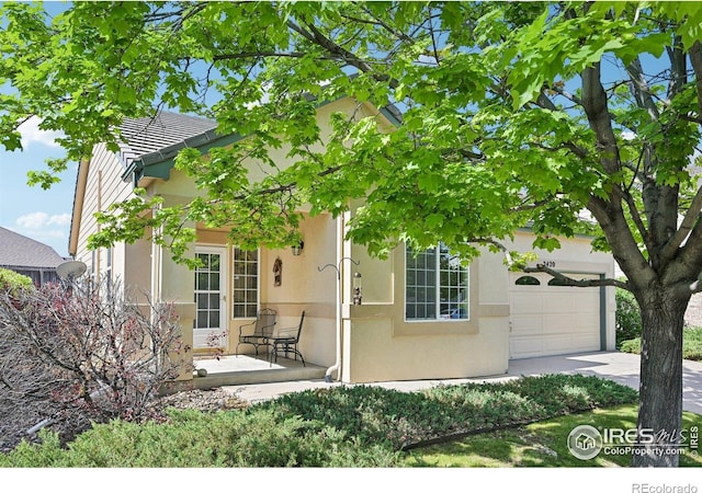 view of front of house featuring stucco siding, an attached garage, and concrete driveway