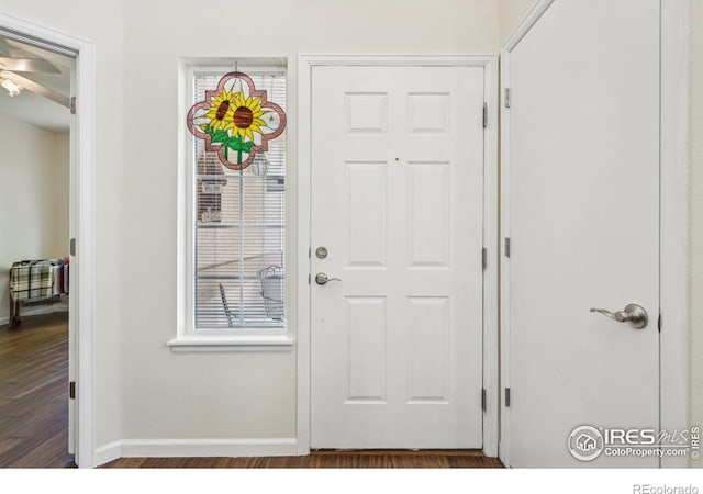 doorway to outside with baseboards, dark wood-style floors, and ceiling fan