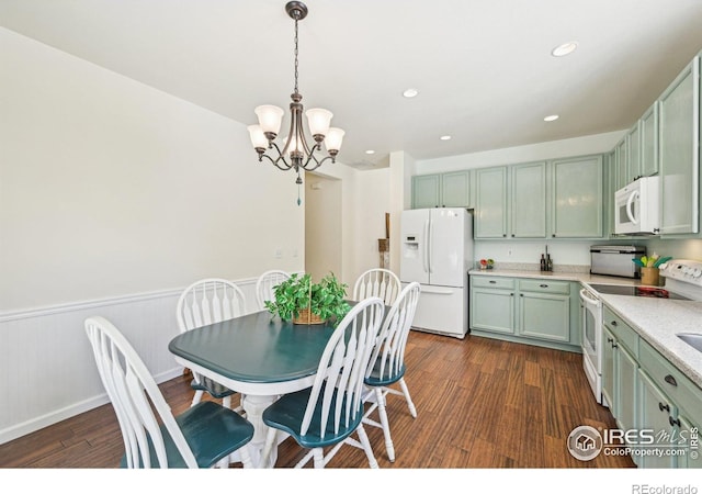 dining space featuring a chandelier, dark wood-type flooring, wainscoting, and recessed lighting