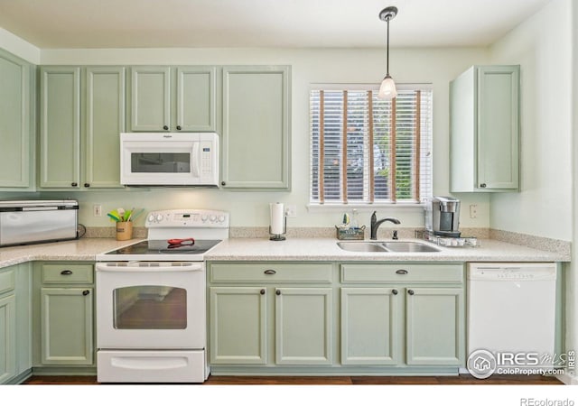 kitchen featuring white appliances, green cabinetry, a sink, and light countertops