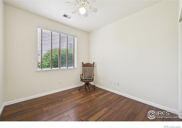 unfurnished room featuring dark wood finished floors, ceiling fan, and baseboards